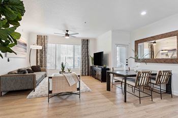 A living room with a brown couch, a coffee table, and a television at The Laurel Apartments, Arizona  .